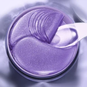 Close-up of shimmering purple SADOER Grape Seed Eye Mask Patches and clear application spatula.