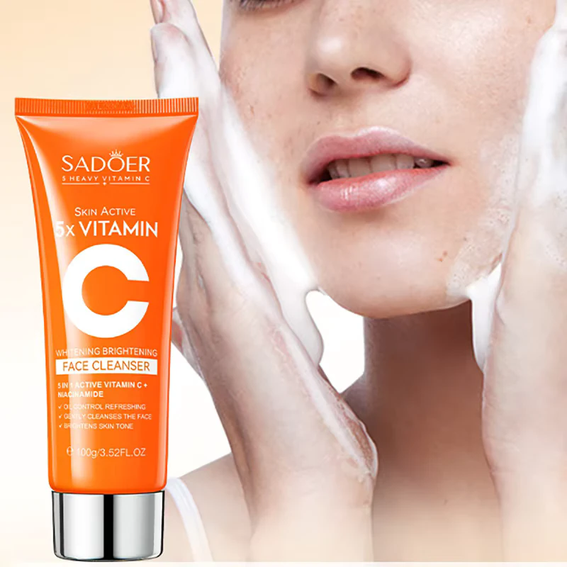 SADOER Vitamin C Facial Cleanser tube beside a person applying the brightening foaming face wash.