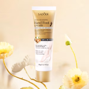SADOER Shea Butter Anti-Cracking Hand & Foot Cream tube with shea butter among pale yellow flowers.